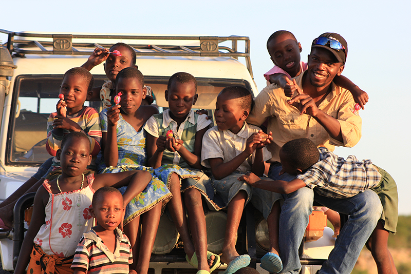Kinder aus Tansania sitzen auf einem Auto