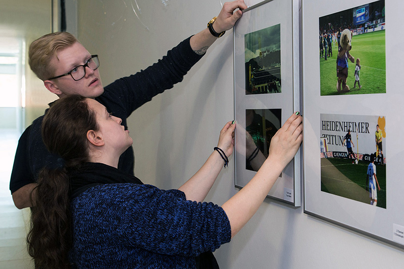 Studierende beim Auhängen der Fotografien