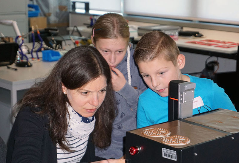 Kinder beobachten Schoko-Druckmaschine