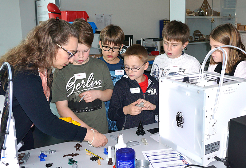 Kinder betrachten gedruckte Teile aus dem 3D-Drucker
