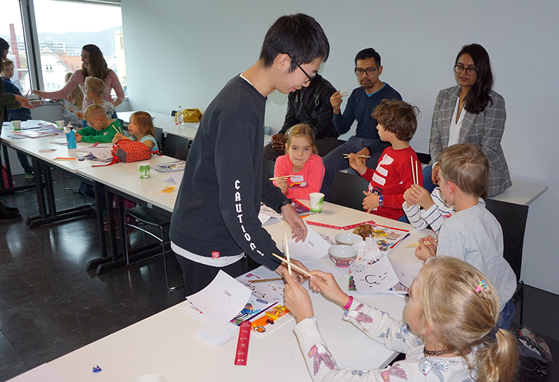 Kinder lernen mit Stäbchen zu essen