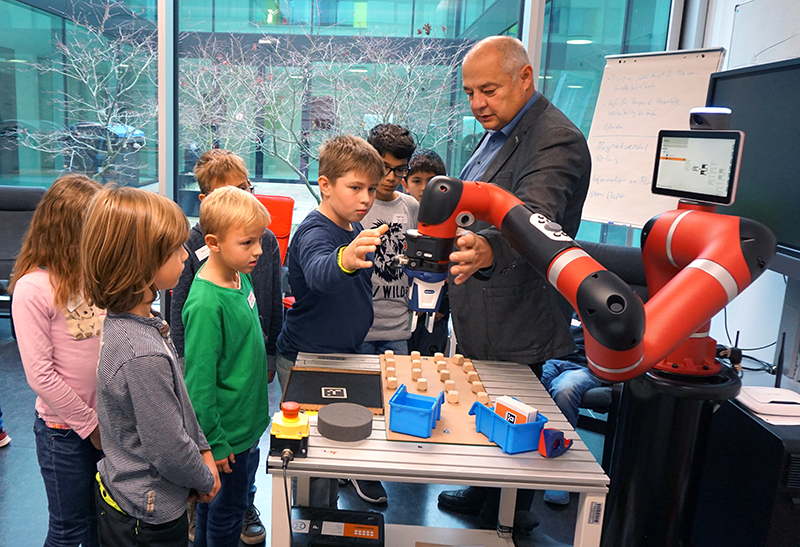 Kinder betrachten einen Roboter