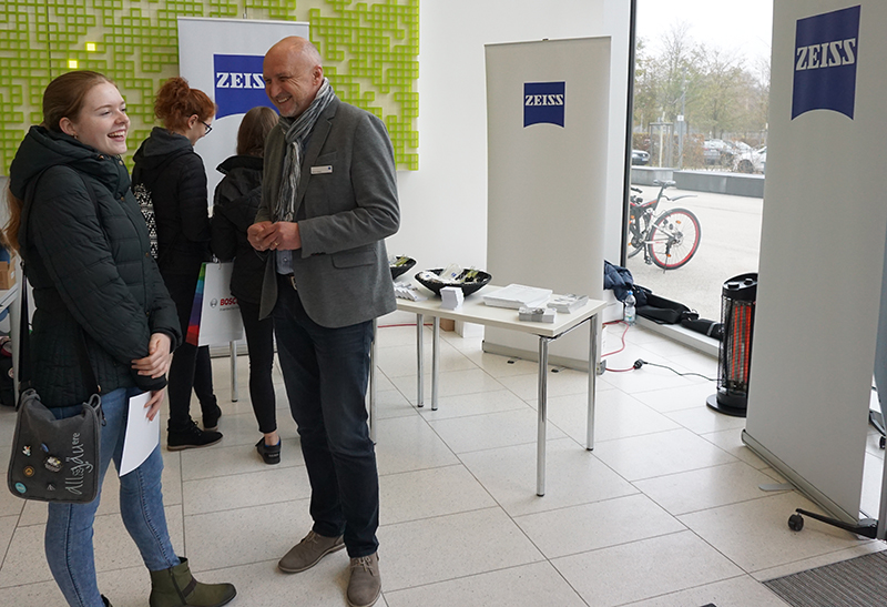 Teilnehmerin des Studieninfotags vor dem Stand der Firma Zeiss