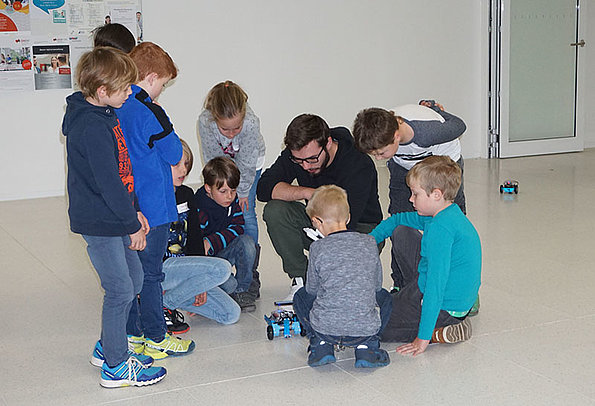 Kinder spielen mit selbstgebauten Roboter-Auto