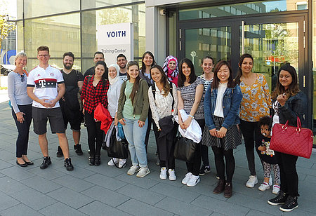 Bridge Year-Teilnehmer*innen besuchen Voith Bridge Yearler*innen vor dem Gebäude des Voith Training Centers