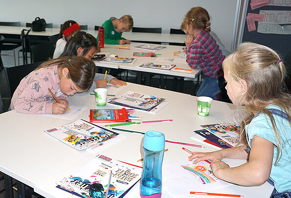 Kinder Uni 2019 Kinder malen einen Regenbogen im Rahmen der Kinder Uni