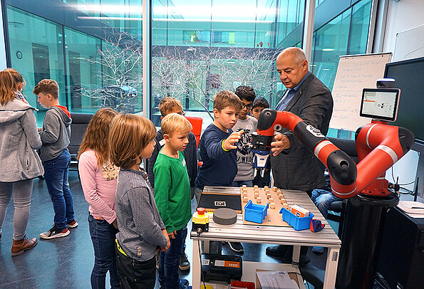 Kinder entdecken die Funktionen eines Roboters bei der Kinder-Uni 2019.